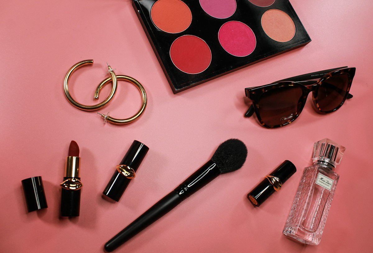 Batons e produtos de maquiagem sobre fundo rosa